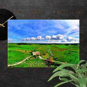 sur le chemin de saint jacques de compostelle, le moulin de la folle apparaît comme une respiration.isolé dans l’immensité verdoyante, bordé par un ruisseau discret, il raconte le lien ancien entre l’homme, l’eau et la terre. vu du ciel, le paysage s’ouvre largement : prairies ondulantes, nuages voyageurs et lignes paisibles du chemin.cette carte postale capture l’âme d’un lieu simple et essentiel, où le pèlerin ralentit, écoute, et laisse le temps faire son œuvre. une image sensible, pensée comme un souvenir à emporter ou à envoyer, témoin d’un passage, d’une halte, d’un instant suspendu.carte postale compostelle le moulin de la folle — entre ciel large et ruisseau secret